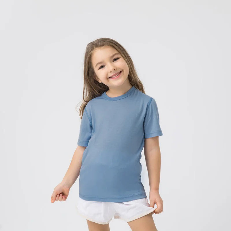 A girl wearing an unisex light blue merino wool breathable t-shirt, studio shot front-view.